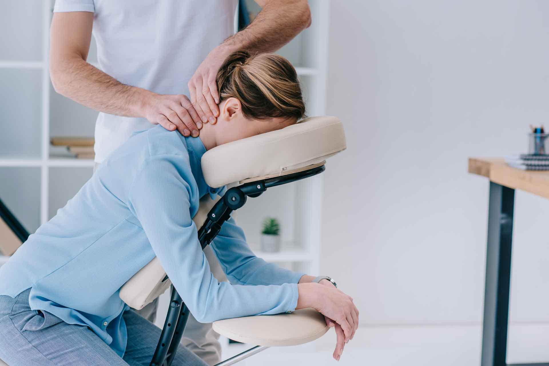 A registered massage therapist massages the back neck of a woman back massage richmond